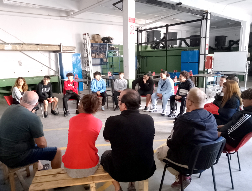 Grupo estudiantes y profesores sentados en círculo